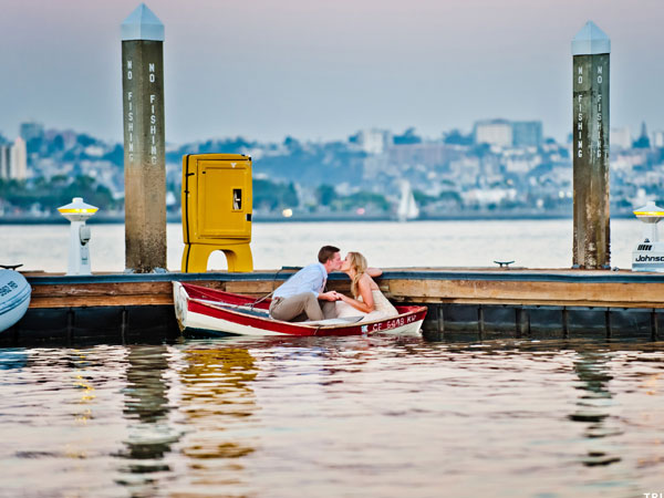 A happy couple on a small boat with the view of San Diego