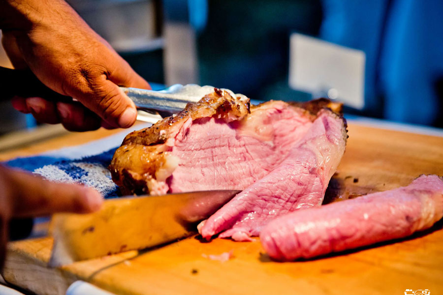 the chef cutting up the meat for dinner