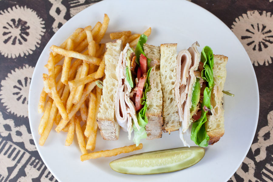 Turkey sandwich with french fries and a pickle